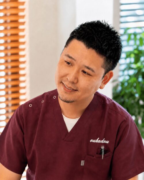 長津田櫻花堂治療院の院長が患者さんの話を聞きながら優しく微笑む様子